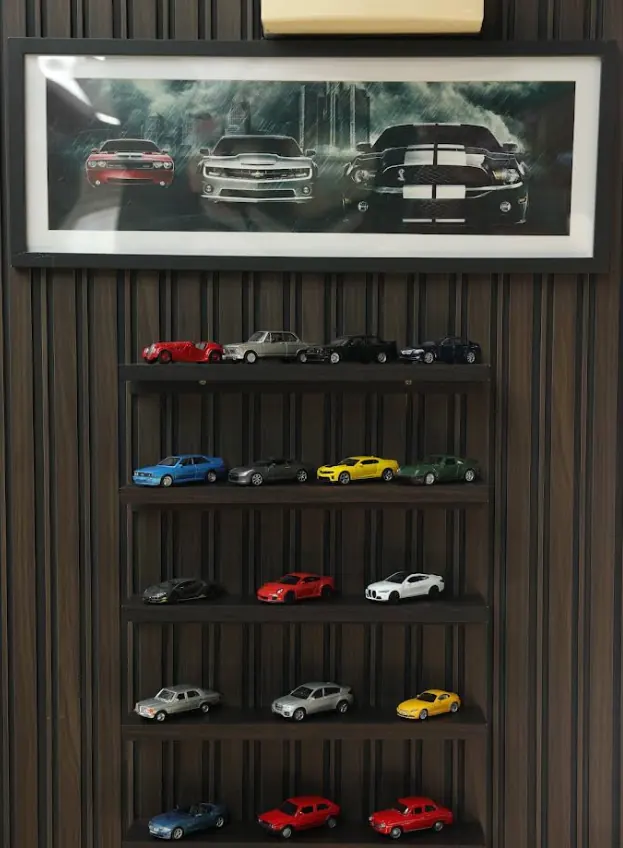 Kolekcija modela automobila na polici u berbernici